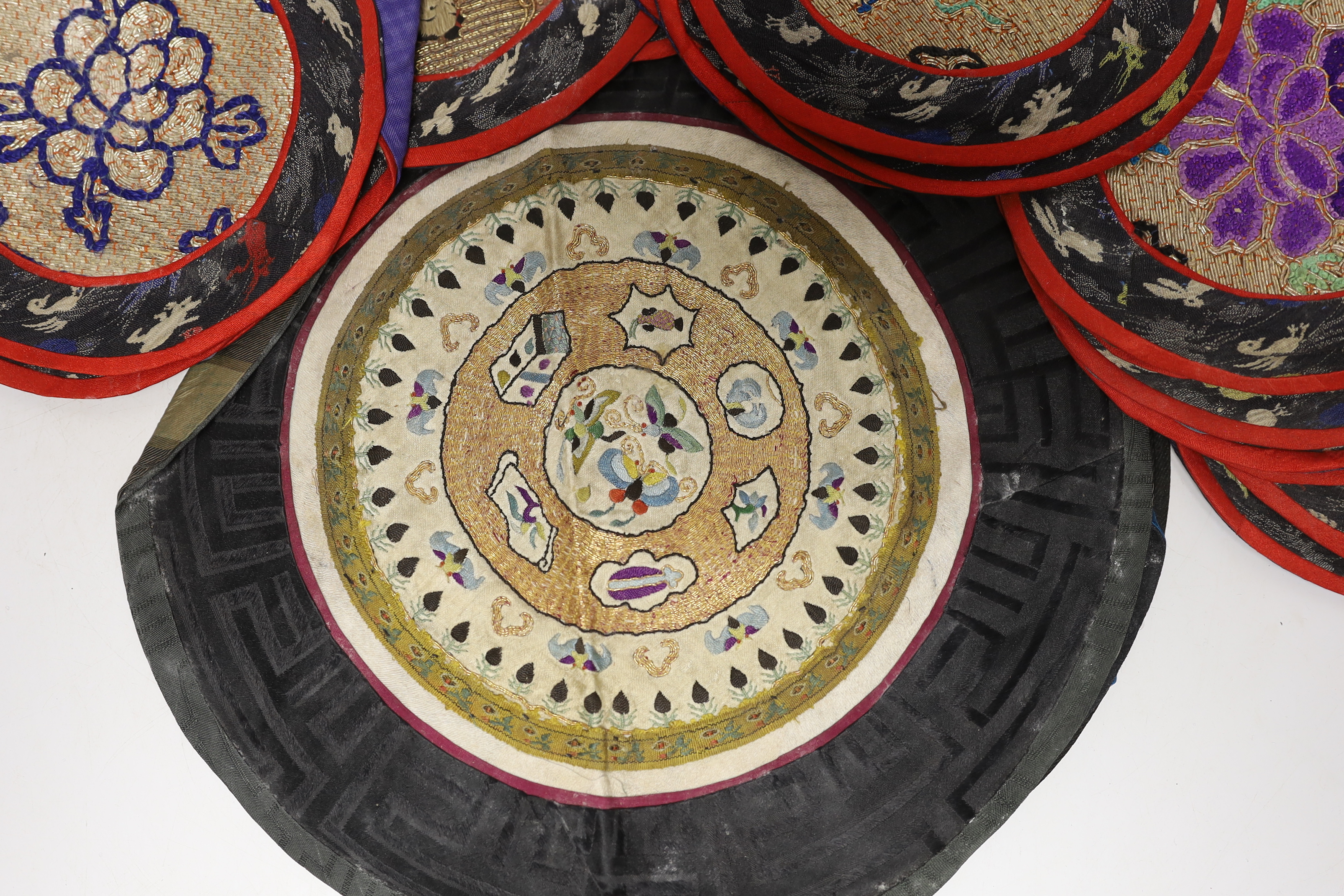 Three sets of six circular Chinese polychrome and gilt thread embroidered mats, a set of four mats and seven other similar various sized embroidered mats, (29)